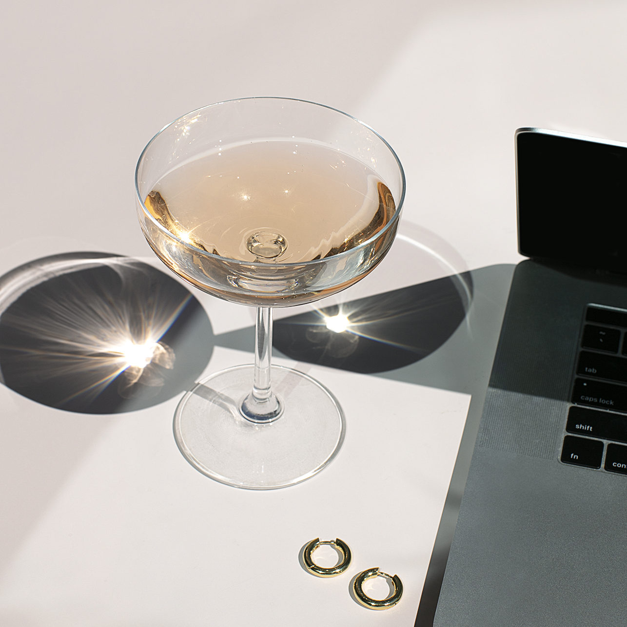 glass of champagne next to entrepreneurs computer